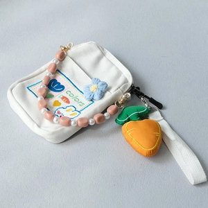 Detail of white canvas bag with colorful rabbit embroidery and pearl beaded strap
