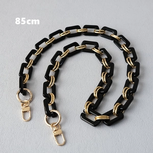 Close-up of 85cm black resin chain with gold metal links and lobster clasps for handbags