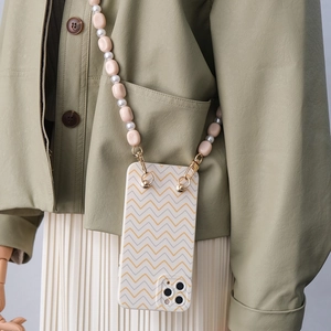 Detail of chevron pattern phone case with long beaded acrylic crossbody strap on model