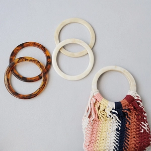 Detail of round resin handles with amber tortoise and marble patterns for DIY bag crafting