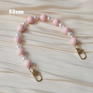 Détail d'une sangle en perles rose et blanc de 32cm avec fermoirs mousquetons dorés
