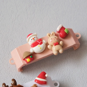 Macro detail of Christmas resin accessories including snowman and gingerbread rabbit