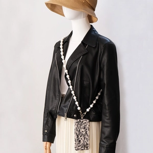Coque de téléphone fleurie avec bandoulière en perles blanches sur un mannequin
