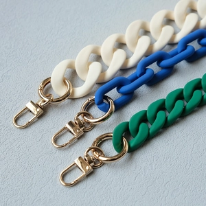 Detail of matte acrylic chunky chains in cream, blue, and green with gold lobster clasps