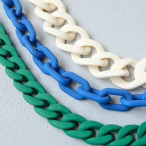 Macro detail of matte acrylic resin chain links in forest green, blue and cream white
