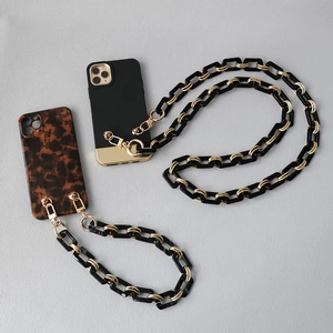 Detail view of black acrylic and gold chain strap set with leopard phone case