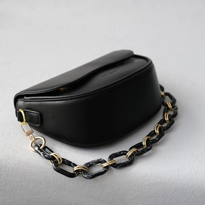 Sac bandoulière noir tendance avec chaîne en résine marbrée et finitions dorées