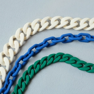 Detail of matte acrylic resin chains in cream white, klein blue, and emerald green