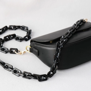 Black saddle bag with matte finish featuring a chunky acrylic chain and gold hardware