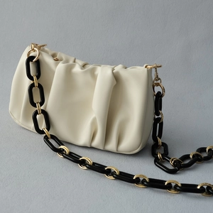 Détail du sac nuage plissé crème avec bandoulière en chaîne épaisse noir et doré