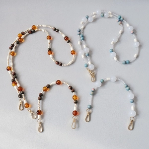 Close-up of colorful acrylic beaded chains with golden lobster clasps for phones or bags