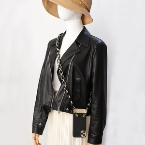 Crossbody black smartphone case with chunky gold and resin chain strap on a model