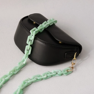 Matte black saddle bag with light green marbled acrylic chain and gold metal clasps