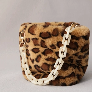 Detail of leopard print faux fur bucket bag with white acrylic chain and gold metal rings