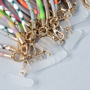 Détail de lanières de téléphone tressées multicolores avec boucles métalliques dorées