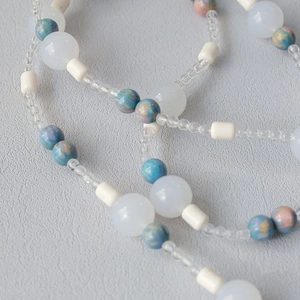 Macro detail of acrylic bead chain with blue pink marble texture and frosted round beads
