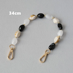 Dettaglio cinturino di 34cm in perle di resina nere, crema e marrone effetto agata