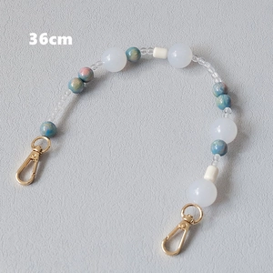 Detail showing 36cm acrylic bead strap with blue marble beads and golden lobster clasps