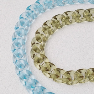 Détail de la grosse chaîne en acrylique translucide de couleur bleu glacier et vert