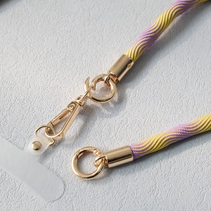 Détail de la dragonne de téléphone tressée violet et jaune avec mousquetons métalliques