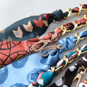 Detail of silk scarf intertwined with gold metal chains in four stylish patterns