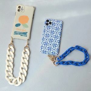 Flat lay of artistic phone cases with colorful chunky acrylic link chain straps