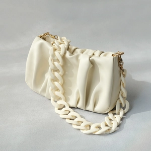 Chic cream dumpling clutch bag featuring trendy acrylic resin chain and soft pleats