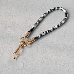 Vue détaillée de la lanière de téléphone tressée zèbre avec clips en métal doré