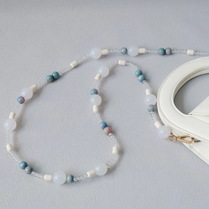Macro shot of colorful acrylic beaded chain with gold lobster clasp for bags and phones
