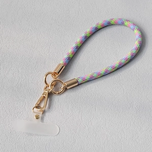 Détail d'une dragonne de téléphone tressée colorée avec attaches dorées et onglet