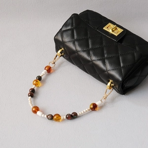 Quilted black leather bag with golden clasp and colorful resin bead chain strap