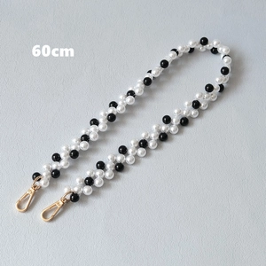 Dettaglio catena di 60cm in perle bianche e nere per borse con moschettoni in oro lucido