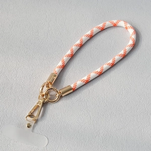 Détail de la lanière de téléphone tressée orange et blanc avec mousqueton doré et pad