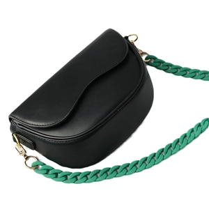 Black matte saddle bag with a chunky vibrant green resin chain strap and gold hardware