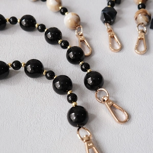 Detail of acrylic bead chain with marble texture beads and golden lobster clasps