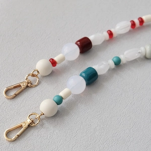 Detail of colorful acrylic beads and bright golden lobster clasp for mobile phone strap