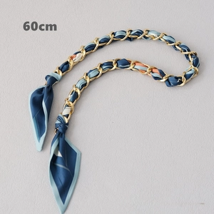Vue détaillée du foulard en soie de 60cm entrelacé avec une chaîne dorée pour sac