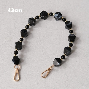 Detail view of a 43cm acrylic bead bag strap with marble texture and gold lobster clasps
