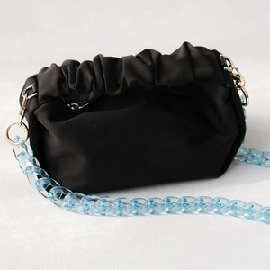 Détail d'un sac nuage plissé noir avec une chaîne en acrylique bleu clair translucide