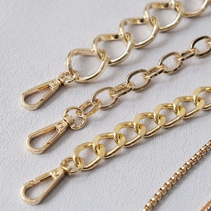 Macro detail of four styles of golden metal bag chains featuring lobster clasps and polished textures