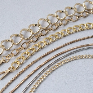 Detailed macro view of various gold and silver metal bag chains in different styles