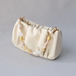 Chic cream dumpling bag with colorful acrylic bead chain handle and soft leather texture