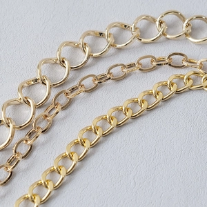 Macro shot of three types of gold metal handbag chains with polished glossy finish