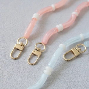 Detail of candy-colored acrylic tube chain with gold lobster clasps and resin beads