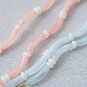 Close-up of pastel acrylic bead strap with pink and blue curved tubes for bags