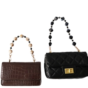 Brown faux crocodile and black quilted handbags with decorative large acrylic bead handles