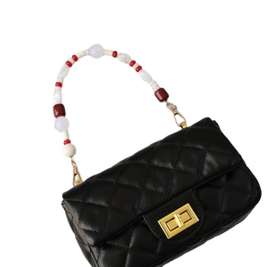 Black quilted leather handbag with colorful acrylic bead handle and golden turn-lock clasp