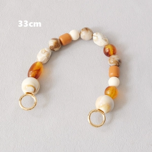 Détail d'une chaîne de 33cm en perles de résine rétro avec texture marbre et ambre