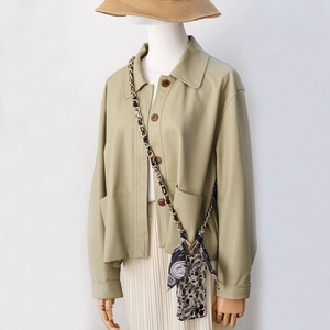 Close-up of a floral crossbody phone case featuring a metal chain and silk scarf detail