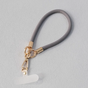 Détail du cordon de téléphone tressé gris avec fermoir en métal doré et patch de connexion